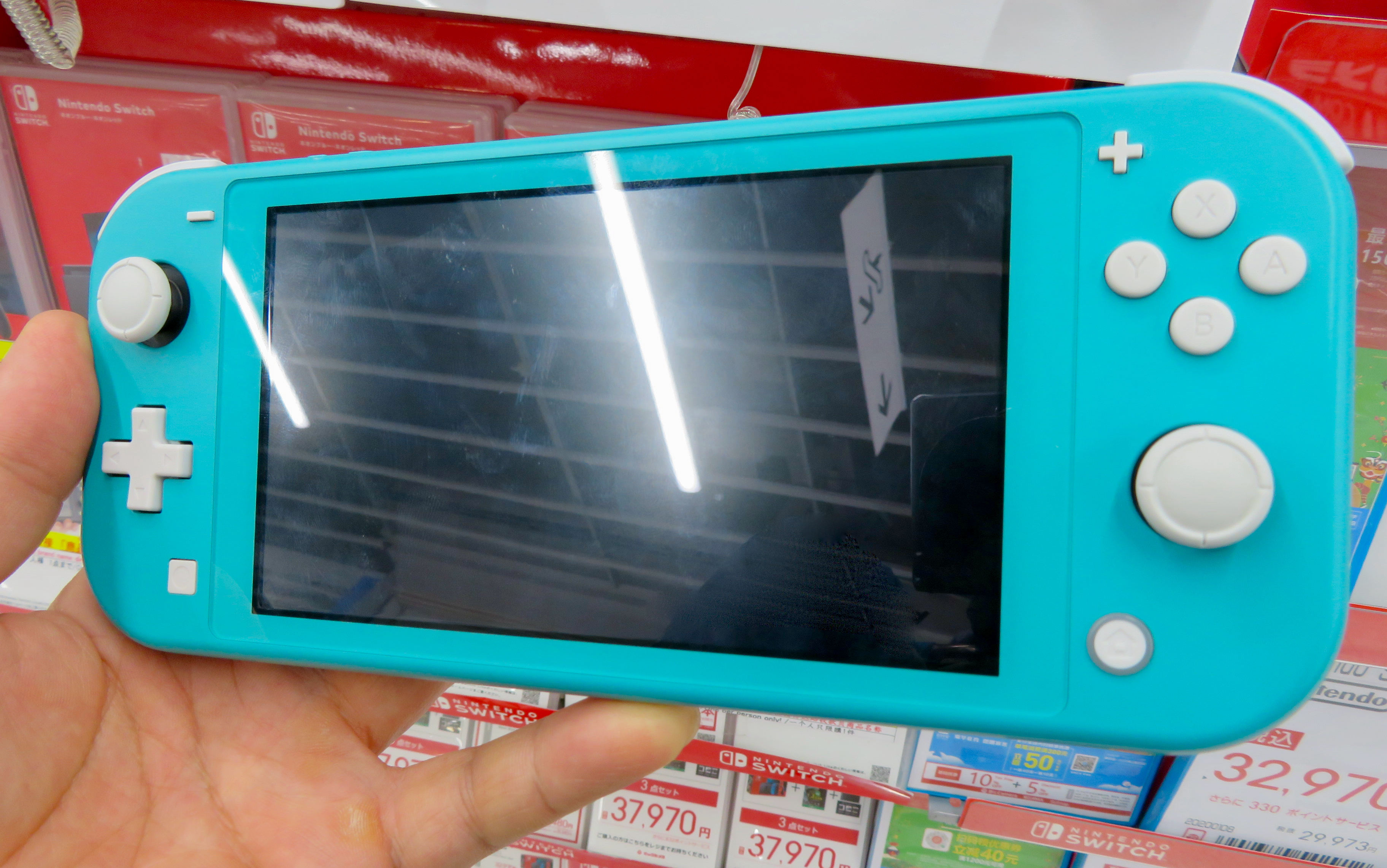 A hold holds a nintendo switch light, turquoise blue.