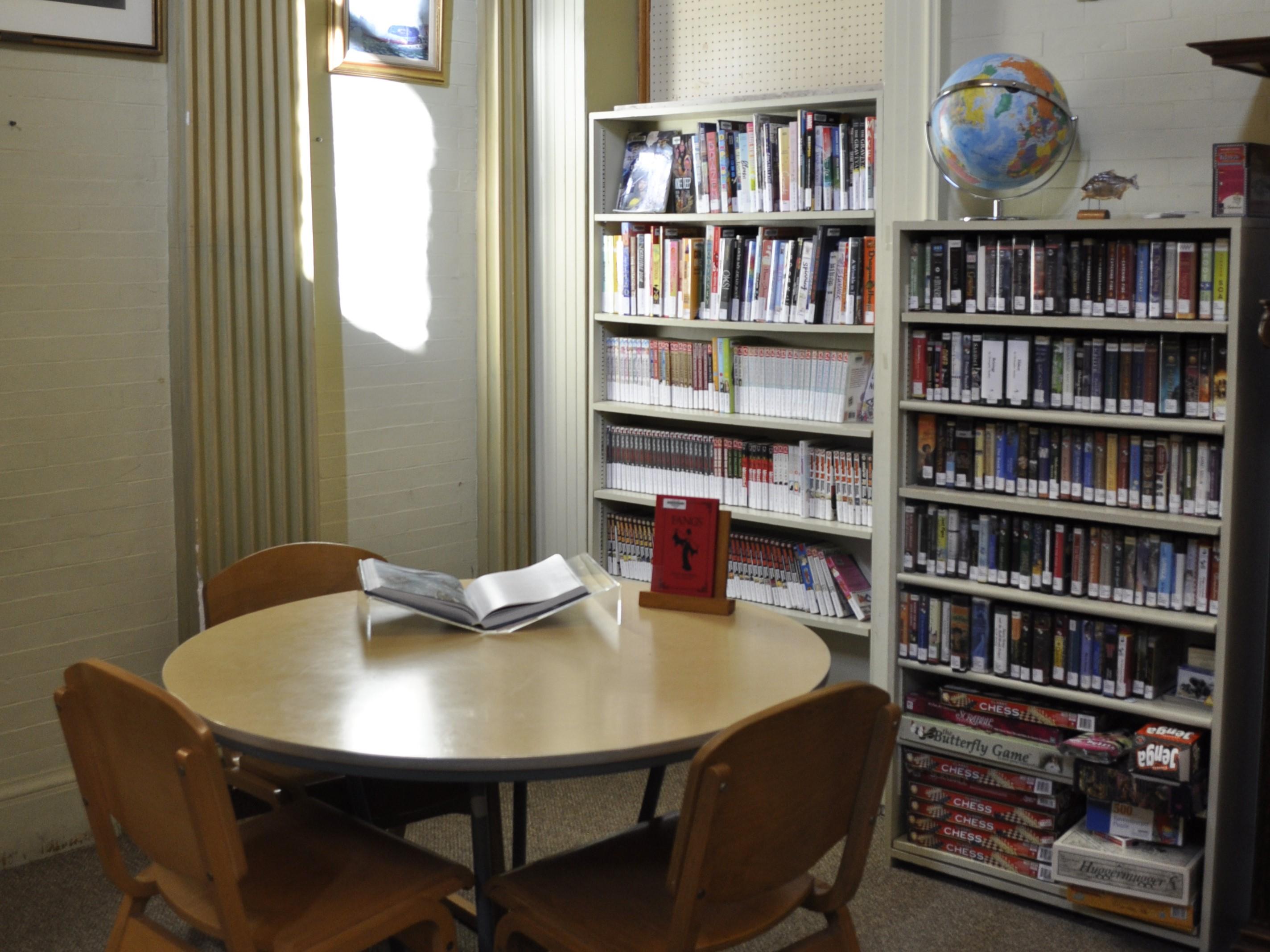 Sunny corner of the teen room with a work table and display shelf.